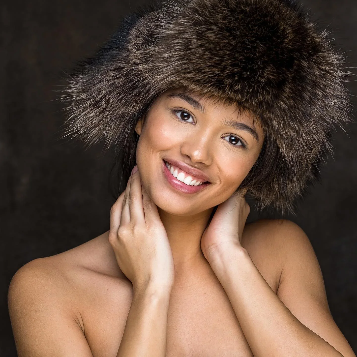 Portrait d’une femme souriante portant une toque en fourrure