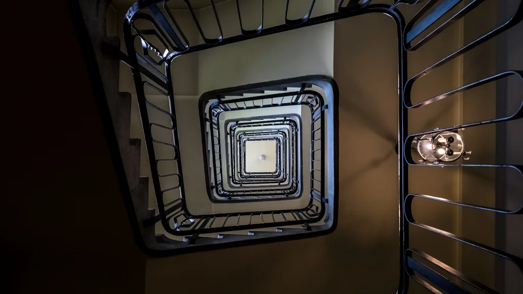 Vue plongeante sur l’escalier intérieur d’un immeuble