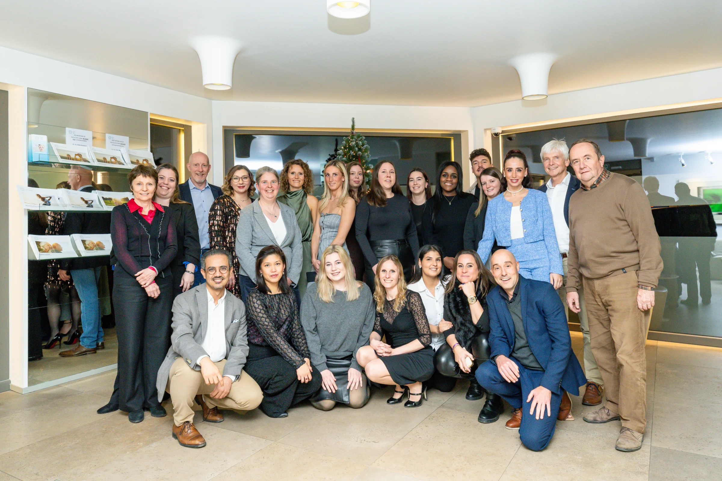 Group photograph of the Focus Eye Clinic team in a reception area, with people standing and others in the foreground