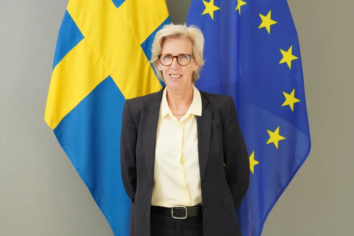 Mikaela Kumlin Granit devant les drapeaux suédois et européen, photographiée par Hani Kanaftchian
